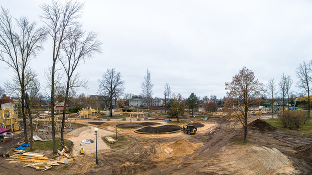 Aerial view of a construction site in a park with wooden structures piles of earth and trees under an overcast sky in Latvia. Aerial view of a construction site in a park with wooden structures piles of earth and trees under an overcast sky in Latvia.