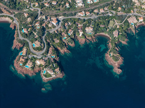 Aerial view of Le Trayas coastline featuring luxury villas with swimming pools winding roads and red rock formations along the Mediterranean Sea in Saint Raphael Provence Alpes Cote d Azur France. Aerial view of Le Trayas coastline featuring luxury villas with swimming pools winding roads and red rock formations along the Mediterranean Sea in Saint Raphael Provence Alpes Cote d Azur France.