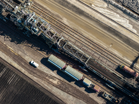 Aerial view of the Tagebau Welzow Sud brown coal open pit mine featuring a large bucket wheel excavator industrial railway tracks and a service vehicle Spremberg Brandenburg Germany. Aerial view of the Tagebau Welzow Sud brown coal open pit mine featuring a large bucket wheel excavator industrial railway tracks and a service vehicle Spremberg Brandenburg Germany.