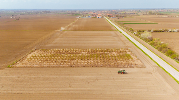 Aerial view of a tractor tilling the soil in a vast open field the straight road cutting through the landscape Sremska Mitrovica Vojvodina Serbia. Aerial view of a tractor tilling the soil in a vast open field the straight road cutting through the landscape Sremska Mitrovica Vojvodina Serbia.