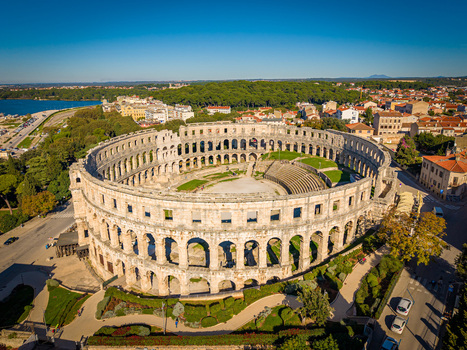 Aerial view of the ancient Roman amphitheater a majestic stone structure stands proudly against the backdrop of the Adriatic Sea and the vibrant cityscape Pula Istria County Croatia.