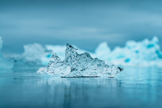 View of a crystalline iceberg fragment resting on the frozen surface of the glacier lagoon near Vatnajokull Iceland.