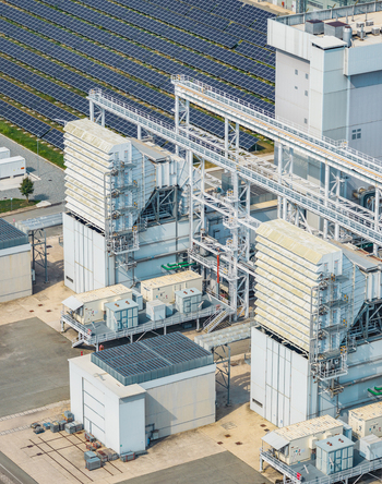Aerial view of industrial heat recovery systems pipelines and photovoltaic panels at a modern gas power facility in Chivasso Piedmont Italy.