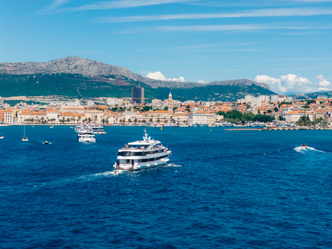Aerial view of the historic city of Split with a large white ferry cruising in the harbor and mountains in the distance Split Split Dalmatia County Croatia. Aerial view of the historic city of Split with a large white ferry cruising in the harbor and mountains in the distance Split Split Dalmatia County Croatia.