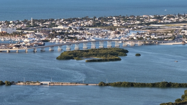 Aerial view of Yucalpeten bridge spanning the blue lagoon waters with boats in the marina and lush green mangroves Progreso Yucatan Mexico. Aerial view of Yucalpeten bridge spanning the blue lagoon waters with boats in the marina and lush green mangroves Progreso Yucatan Mexico.