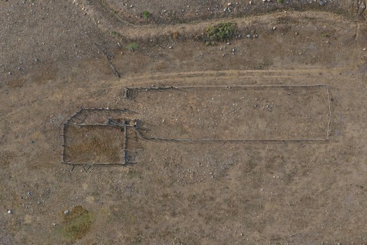 Aerial view of a rustic wooden livestock corral set in a dry arid landscape with sparse vegetation in Golden Colorado United States.