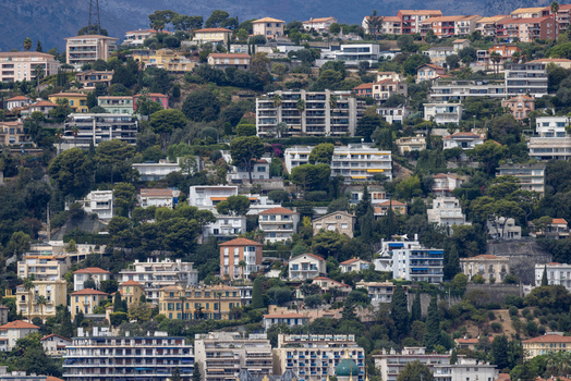 Aerial view of the hillside in Nice featuring dense residential buildings lush trees and Mediterranean architecture in Nice Provence Alpes Cote d Azur France. Aerial view of the hillside in Nice featuring dense residential buildings lush trees and Mediterranean architecture in Nice Provence Alpes Cote d Azur France.