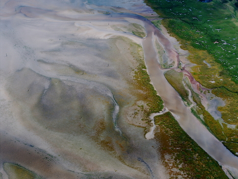 Aerial view of abstract tidal patterns at Culbin Sands featuring intricate sand formations winding water channels and coastal vegetation in Nairn Scotland United Kingdom. Aerial view of abstract tidal patterns at Culbin Sands featuring intricate sand formations winding water channels and coastal vegetation in Nairn Scotland United Kingdom.