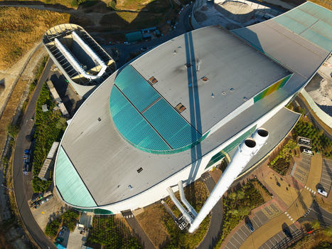 Aerial view of the Energy Recovery Facility with its distinctive curved roof and tall chimneys situated within an industrial site in Bicester England United Kingdom.