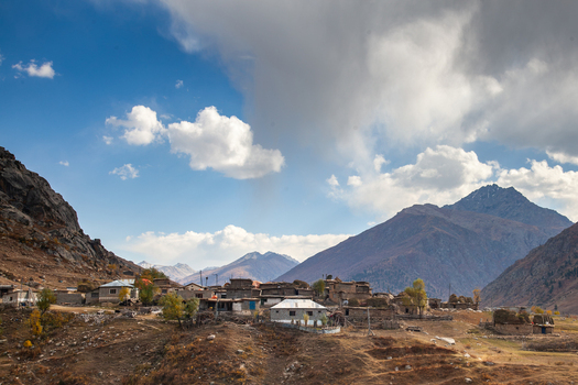View of Astore Valley featuring a small village with traditional stone houses nestled among rugged mountain slopes under a bright blue sky in Astore Gilgit Pakistan. View of Astore Valley featuring a small village with traditional stone houses nestled among rugged mountain slopes under a bright blue sky in Astore Gilgit Pakistan.