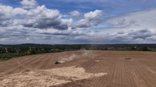 Aerial view of a tractor plowing a dry field Portugal. Aerial view of a tractor plowing a dry field Portugal.