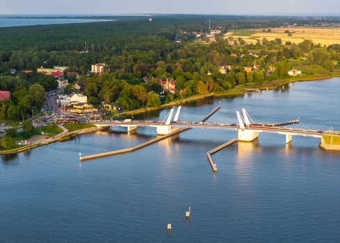 Aerial view of the Sobieszewo Bridge crossing the Martwa Wisla river surrounded by lush green forests and coastal landscape in Gdansk Pomeranian Voivodeship Poland.