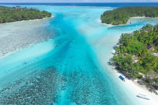 View of the turquoise lagoon and coral reefs surrounding the lush tropical islands of Moorea Maiao Windward Islands French Polynesia.