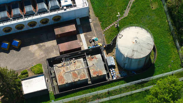 Aerial view of the industrial infrastructure of a data centre featuring storage tanks cooling systems and shipping containers surrounded by green lawns Wellingborough England United Kingdom. Aerial view of the industrial infrastructure of a data centre featuring storage tanks cooling systems and shipping containers surrounded by green lawns Wellingborough England United Kingdom.