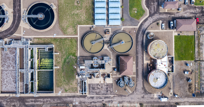 Aerial view of the wastewater treatment plant featuring circular clarifiers aeration tanks and facility buildings in Woodburn Oregon United States. Aerial view of the wastewater treatment plant featuring circular clarifiers aeration tanks and facility buildings in Woodburn Oregon United States.