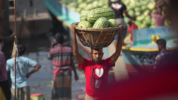 View of a man carrying watermelons on his head at Sadarghat Bangladesh.