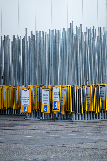 View of a large collection of metal poles with yellow and blue parking signs stored in a traffic signs depot in Zaandam North Holland Netherlands.
