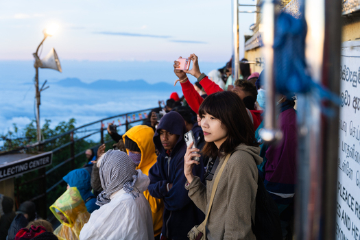 Ratnapura Sri Lanka 23 February 2026 View of pilgrims and tourists gathered at the summit of Adam s Peak to watch the sunrise above a sea of clouds.