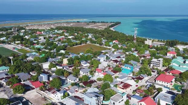 Aerial view of Kudahuvadhoo coastal town and rooftops Maldives. Aerial view of Kudahuvadhoo coastal town and rooftops Maldives.