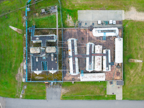 Aerial view of an industrial storage facility featuring multiple cylindrical tanks interconnected piping and a fenced perimeter situated in a grassy area in Olaine Olaine Municipality Latvia. Aerial view of an industrial storage facility featuring multiple cylindrical tanks interconnected piping and a fenced perimeter situated in a grassy area in Olaine Olaine Municipality Latvia.
