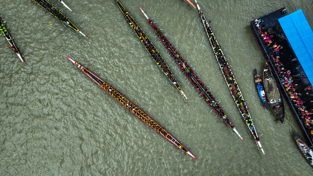 Baghabari Bangladesh 20 August 2022 Aerial view of long traditional boats competing in a boat race on the river with many rowers paddling in unison.
