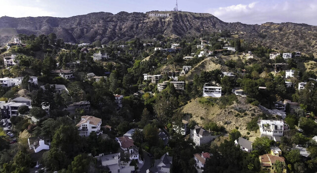 Hollywood CA United States 29 September 2026 Aerial view of the iconic Hollywood Sign perched on the hills above a dense residential neighborhood with lush trees.