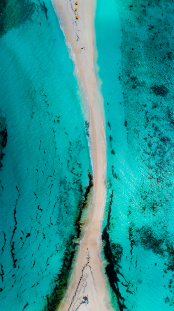 Aerial view of Los Roques archipelago featuring a narrow white sandbar surrounded by vibrant turquoise Caribbean waters and coral reefs in Los Roques Dependencias Federale Venezuela. Aerial view of Los Roques archipelago featuring a narrow white sandbar surrounded by vibrant turquoise Caribbean waters and coral reefs in Los Roques Dependencias Federale Venezuela.