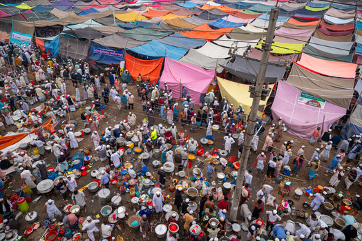 Tongi Bangladesh 31 January 2025 Aerial view of Tongi Ijtema Maidan with a vast gathering of people under colorful tents cooking pots and supplies spread across the ground.