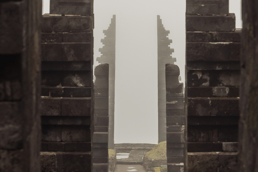 View of the ancient stone gateway of Cetho Temple shrouded in thick white mist and fog Kecamatan Jenawi Jawa Tengah Indonesia. View of the ancient stone gateway of Cetho Temple shrouded in thick white mist and fog Kecamatan Jenawi Jawa Tengah Indonesia.