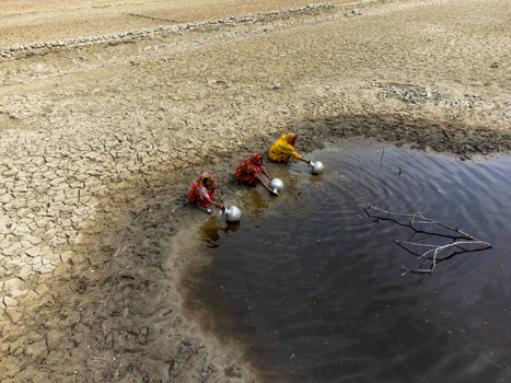 Gabura Union Bangladesh 25 April 2025 Aerial view of three women in colorful saris collecting water from a small pool amidst a parched landscape with cracked earth. Gabura Union Bangladesh 25 April 2025 Aerial view of three women in colorful saris collecting water from a small pool amidst a parched landscape with cracked earth.