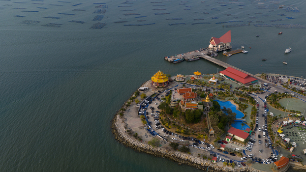 Aerial view of Koh Loi temple complex with its distinctive yellow pagoda traditional Thai buildings and a long pier extending into the sea in Si Racha Chon Buri Thailand. Aerial view of Koh Loi temple complex with its distinctive yellow pagoda traditional Thai buildings and a long pier extending into the sea in Si Racha Chon Buri Thailand.