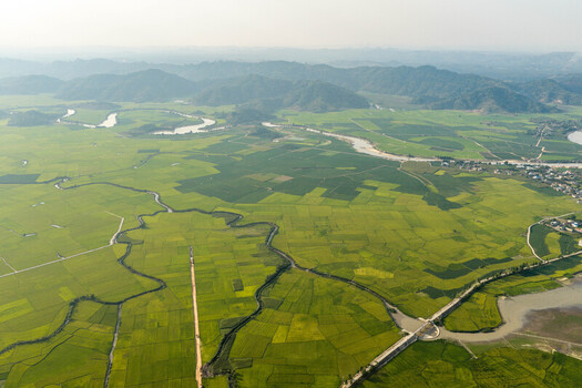 Aerial view of Lak Lake surrounded by lush green rice paddies and winding rivers in Lien Son Lak Dak Lak Vietnam. Aerial view of Lak Lake surrounded by lush green rice paddies and winding rivers in Lien Son Lak Dak Lak Vietnam.