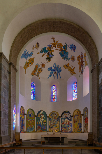 View of the modern mosaics and murals by Carl Henning Pedersen in the apse of Ribe Cathedral with stained glass windows and stone arches in Ribe Denmark. View of the modern mosaics and murals by Carl Henning Pedersen in the apse of Ribe Cathedral with stained glass windows and stone arches in Ribe Denmark.