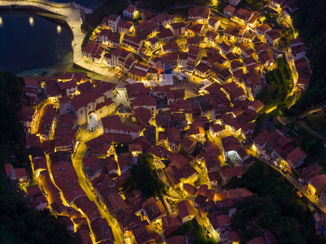 Aerial view of the illuminated coastal town of Cudillero at night with its characteristic red rooftops and harbor in Cudillero Asturias Spain. Aerial view of the illuminated coastal town of Cudillero at night with its characteristic red rooftops and harbor in Cudillero Asturias Spain.