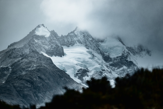 View of the snow capped peaks of the Andes mountains shrouded in dramatic clouds near El Calafate Santa Cruz Province Argentina.