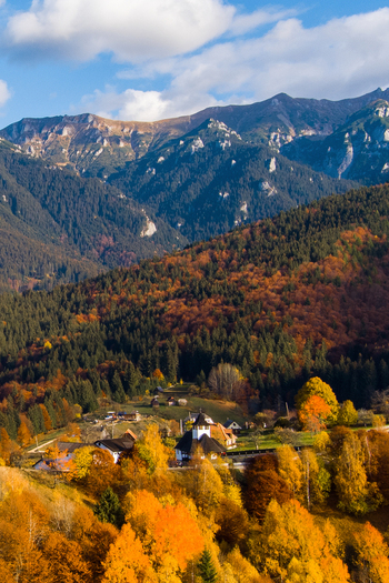 Aerial view of Bran Castle surrounded by vibrant autumn foliage and the Carpathian mountains in Bran Brasov Romania. Aerial view of Bran Castle surrounded by vibrant autumn foliage and the Carpathian mountains in Bran Brasov Romania.