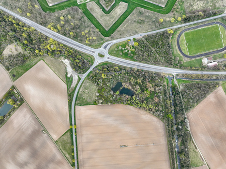 Aerial view of the intricate star shaped fortress blending with modern infrastructure and fields an intersection of history and contemporary life Neuf Brisach Grand Est France.