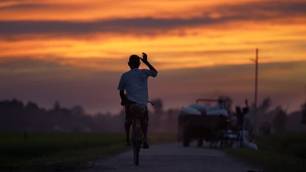 View of a man riding a bicycle at sunset in Bogura Bangladesh. View of a man riding a bicycle at sunset in Bogura Bangladesh.
