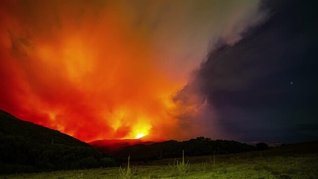 View of a wildfire burning on a hillside in Spain.