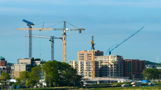 Aerial view of tower cranes at a construction site for modern apartment buildings near the Oosterdel nature reserve Broek op Langedijk Noord Holland Netherlands. Aerial view of tower cranes at a construction site for modern apartment buildings near the Oosterdel nature reserve Broek op Langedijk Noord Holland Netherlands.