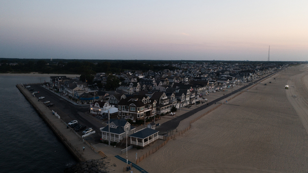 Aerial view of Manasquan Beach with its coastal houses sandy shoreline and calm ocean waters at dusk in Manasquan New Jersey United States. Aerial view of Manasquan Beach with its coastal houses sandy shoreline and calm ocean waters at dusk in Manasquan New Jersey United States.