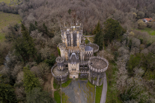 Aerial view of Butron Castle surrounded by dense forest and trees in Butroi Euskadi Spain. Aerial view of Butron Castle surrounded by dense forest and trees in Butroi Euskadi Spain.