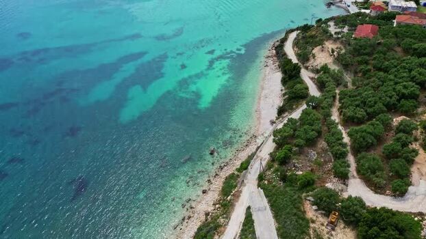 Aerial view of turquoise sea and coastal road in Greece.