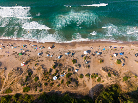 Aerial view of Coral Beach with sandy dunes scattered tents and turquoise sea waves in Tsarevo Burgas Bulgaria. Aerial view of Coral Beach with sandy dunes scattered tents and turquoise sea waves in Tsarevo Burgas Bulgaria.