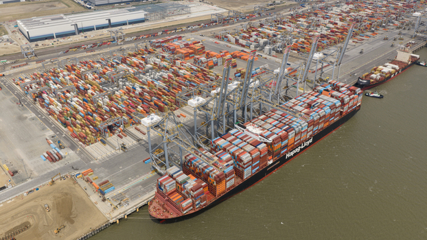 Corringham United Kingdom 10 July 2026 Aerial view of Solent Stevedores London Gateway with a Hapag Lloyd ship docked by cranes and rows of colorful shipping containers.