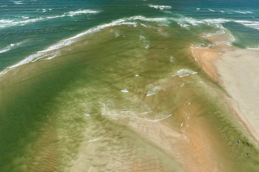 Aerial view of Matanzas Inlet showing shifting sandy shoals turquoise water and gentle waves along the coastline in St. Johns County Florida United States. Aerial view of Matanzas Inlet showing shifting sandy shoals turquoise water and gentle waves along the coastline in St. Johns County Florida United States.