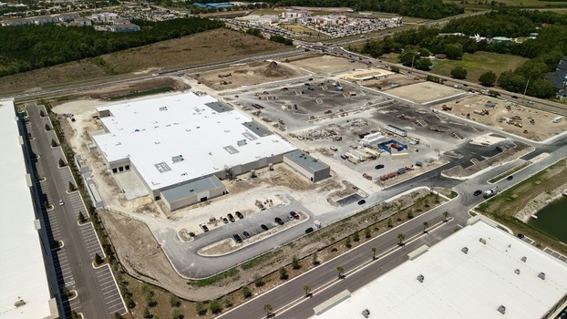 Aerial view of a large commercial warehouse under construction at Foundry Lane with surrounding dirt lots and parking areas in World Golf Village Florida United States.