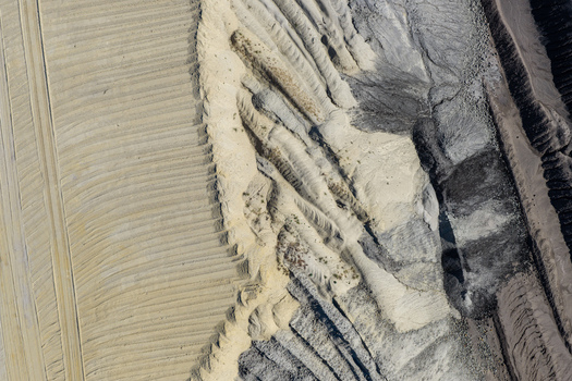 Aerial view of the Tagebau Welzow Sud brown coal open pit mine showing contrasting layers of sand clay and dark coal deposits with deep excavation ridges in Spremberg Brandenburg Germany. Aerial view of the Tagebau Welzow Sud brown coal open pit mine showing contrasting layers of sand clay and dark coal deposits with deep excavation ridges in Spremberg Brandenburg Germany.