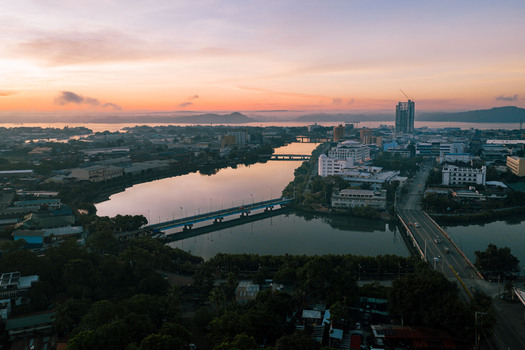 Aerial view of bridges spanning the tranquil waters reflecting the soft glow of dawn amidst the urban skyline Iloilo City Philippines. Aerial view of bridges spanning the tranquil waters reflecting the soft glow of dawn amidst the urban skyline Iloilo City Philippines.