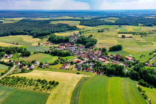 Aerial view of Neunkirchen am Brand with residential houses surrounded by lush green meadows cultivated fields and dense forests Neunkirchen am Brand Bavaria Germany. Aerial view of Neunkirchen am Brand with residential houses surrounded by lush green meadows cultivated fields and dense forests Neunkirchen am Brand Bavaria Germany.
